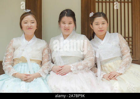 Das Dorf Bukchon Hanok, Seoul, Südkorea. Ein Porträt von drei jungen koreanischen Frauen im traditionellen Outfit. Stockfoto