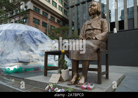 Seoul, Südkorea. Die Statue des Friedens, auch Komfort Frau statue sitzt mit Blick auf japanische Botschaft zusammen mit Shift Camp machen Website von Aktivisten. Stockfoto