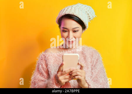 Elegante junge Frau mit Sonnenbrille und trägt weichen Pelz auf dem Telefondisplay. Stockfoto