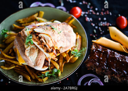 Leckeres Rippen Sandwich mit pommes frites und frischem Gemüse Stockfoto