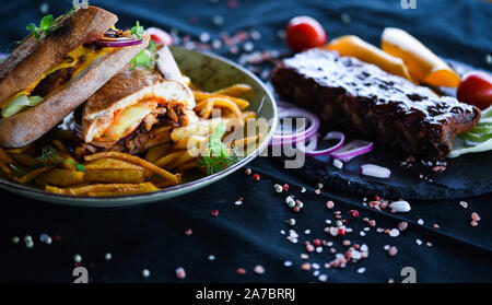 Leckeres Rippen Sandwich mit pommes frites und frischem Gemüse Stockfoto