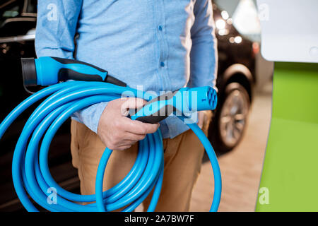 Holding Ladekabel für Elektrofahrzeuge im Autohaus, Nahaufnahme Stockfoto