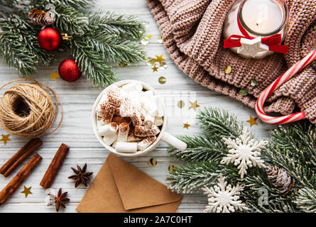 Weihnachtsbaum Kiefer Zweige mit Dekorationen und heiße Schokolade an einem hölzernen Tisch. Urlaub Hintergrund mit Copyspace. Ansicht von oben Stockfoto