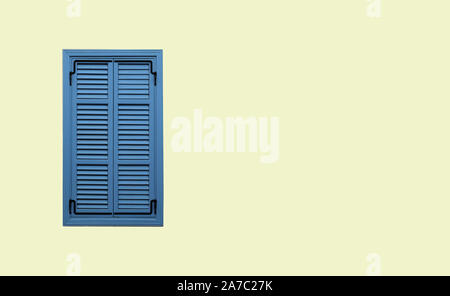 Vorderansicht des ordentlich blaues Fenster mit geschlossenen Fensterläden auf beige gestreiften Stuck Wand Nahaufnahme mit Freiraum für Text auf der rechten Seite Stockfoto
