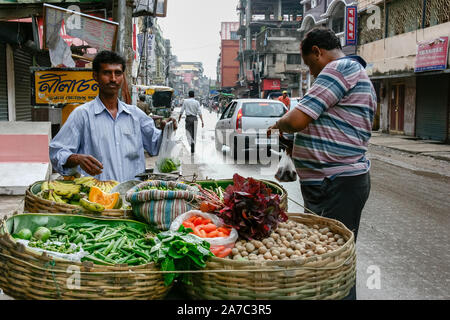 Kolkata, Indien - 14. November 2019: Anbieter inder Verkauf von frischen Gemüse und Obst (Kartoffel, Okra, Banane) auf seinem Stand auf der Straße in t Stockfoto