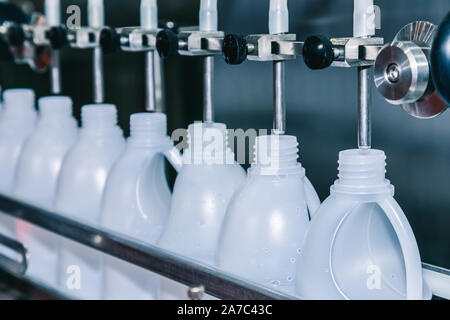 Weißer Kunststoff Gallonen oder Flasche auf der Produktionslinie des Förderbandes an der Füllmaschine in der Fabrik. Selektive konzentrieren. Industrie und Technik c Stockfoto
