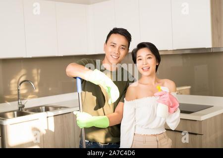 Hausfrau und ihr Mann Reinigung zu Hause und gemeinsam Spaß haben. Die allgemeine Ordnung und Sauberkeit, Home und Reinigung Service Konzept Stockfoto