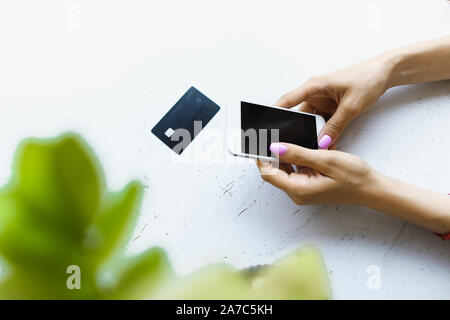 Weiblichen kaukasischen Hände halten Kreditkarte und Smartphone in weißen Hintergrund. Stockfoto