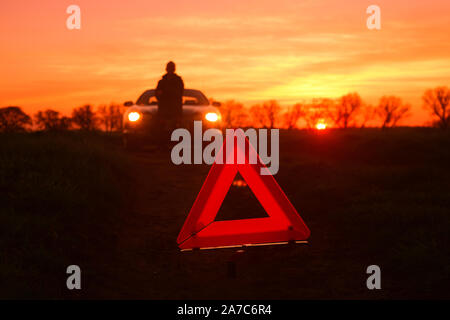 Warndreieck durch den Fahrer mit Panne mit dem Auto auf der Landstraße bei Sonnenuntergang york Vereinigtes Königreich Stockfoto