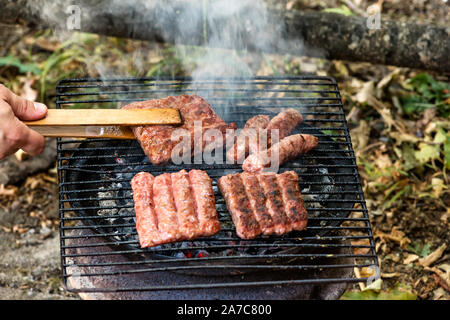 Balkan Küche Schwein Cevapi, gegrillte Hackfleisch, auf dem improvisierten Grill Stockfoto