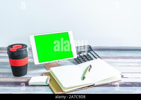Büro und Schule Schreibwaren Bürobedarf, wiederverwendbare Cup und mobilen Tablet mit Green Screen. Business Objects Technologie Konzept. Stockfoto