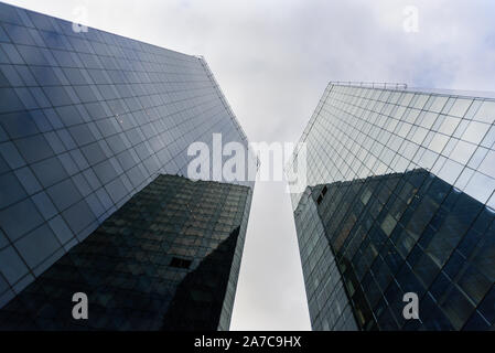 Zwei Wolkenkratzer aus Glas von unten gemacht mit grauen bewölkten Himmel Stockfoto