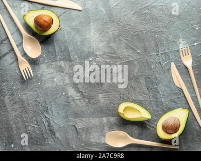 Avocado Samen Biologisch abbaubare Single-Use Besteck. Biokunststoff - eine tolle Alternative zu Plastik einweg Besteck. Ansicht von oben, flach. Grauer Hintergrund Stockfoto