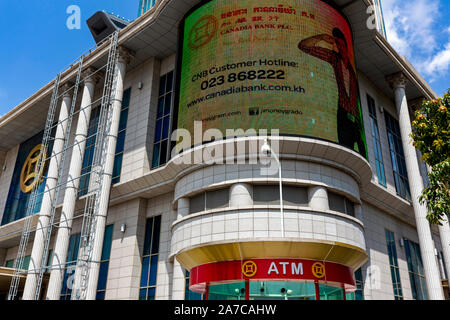 Einen großen digitalen elektronischen Reklametafeln wirbt für Bankdienstleistungen über einen Geldautomaten an Canadia Bank Tower in Phnom Penh, Kambodscha. Stockfoto