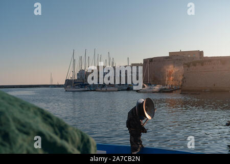 Gallipoli, Italien, 20. August 2019: Leere fischer Boot ist in der Nähe von gallipoli Schloss an der Sunset angedockt Stockfoto