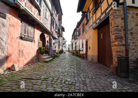 Eguisheim, Frankreich - 24. März 2019: Straße mit Fachwerkhäuser mittelalterlichen Häuser in Eguisheim Dorf an der berühmten Weinstraße im Elsass. Stockfoto