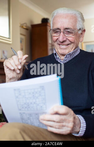 Ältere Menschen tun Sudoku Puzzle zu Hause Stockfoto