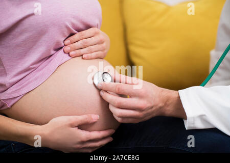 In der Nähe von Doktor mit Stethoskop zu prüfen schwangere Frau Stockfoto