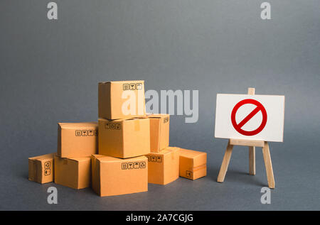 Ein Stapel Stapel Kartons und ein Zeichen stehen mit rotem Symbol Nr. Beschränkung bei der Einfuhr von Waren, proprietäre für Unternehmen. Embargo, Handel wa Stockfoto
