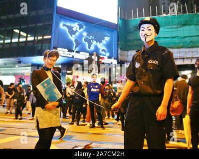 Hongkong, China. 31 Okt, 2019. Tausende von Menschen tragen Masken und Kostüme marschierten durch die Innenstadt von Hong Kong auf Halloween Nacht und landete im Bezirk von Lan Kwai Fong im Zentrum. Nach Mitternacht Auseinandersetzungen ausbrach und die Polizei feuerte Tränengas, um die Straßen zu löschen. Credit: Gonzales Foto/Alamy leben Nachrichten Stockfoto