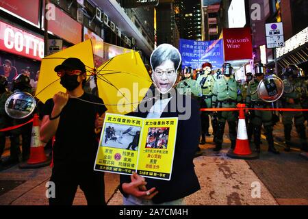 Hongkong, China. 31 Okt, 2019. Tausende von Menschen tragen Masken und Kostüme marschierten durch die Innenstadt von Hong Kong auf Halloween Nacht und landete im Bezirk von Lan Kwai Fong im Zentrum. Nach Mitternacht Auseinandersetzungen ausbrach und die Polizei feuerte Tränengas, um die Straßen zu löschen. Credit: Gonzales Foto/Alamy leben Nachrichten Stockfoto
