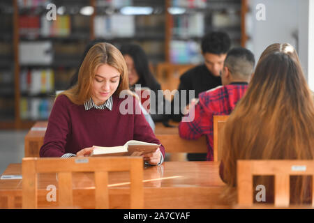 (191101) - NANCHANG, November 1, 2019 (Xinhua) - Melchakova Nataliia liest ein Buch in der Bibliothek der East China Jiaotong University in Nanchang, Osten Chinas Provinz Jiangxi, Okt. 31, 2019. Melchakova Nataliia, eine 21-jährige russische Mädchen, kam nach Osten China Jiaotong University für ein halbes Jahr Studium als Austauschstudent in 2018. Nach ihrem Studium in Russland beendete, fand sie sich stark in der chinesischen Kultur interessiert und beschlossen, wieder zu East China Jiaotong University für weitere Studien zu gehen. "Ich liebe die Musik und das Essen hier. Es ist so wunderbar!" sagte Nataliia. (Xinhua / Hu Chenhuan) Stockfoto