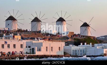 Mykonos, Griechenland: Iconic Windmühlen der Insel Mykonos bei einem Sonnenuntergang nach einem Sommer sonnigen Tag entlang der blauen Meer Stockfoto