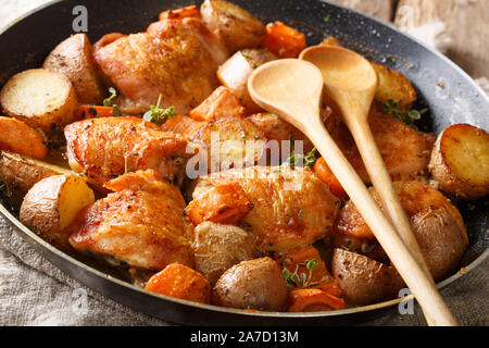 Gebackene Hähnchenteile mit Gemüse und Kräutern close-up in einer Pfanne auf dem Tisch. Horizontale Stockfoto