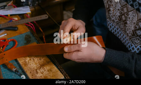 Skinner arbeiten mit Leder Gürtel Stockfoto