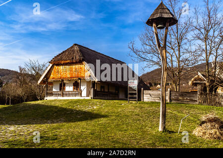 Traditionelle Ungarische Haus und eine Glocke in Szentendre Skanzen Village Museum an einem sonnigen Frühlingstag. Stockfoto