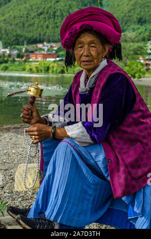 Mosuo Frauen beten durch das Wasser der Lugu See in XiaLuoShi, Lugu See, Yunnan, China Stockfoto