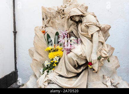 Rote Rose in der Hand auf Statue in den Friedhof gelegt. Stockfoto