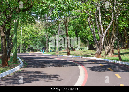 Campo Grande-MS, Brasilien - 30. Oktober 2019: Wanderweg und Radweg der Park der Nationen, Indigenen, umgeben von Bäumen. Stockfoto