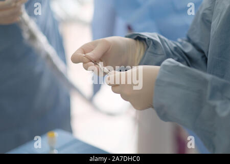 Arzt mit dem Assistenten bereiten Sie die Ausrüstung für chirurgische Zahnärztliche Chirurgie in der Klinik Stockfoto