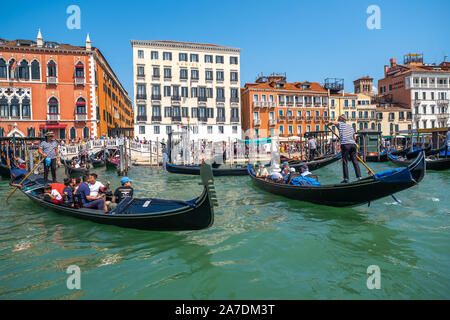 Venedig, Italien - 3. August 2019: Gandoliers fahren Touristen auf Gondeln am Canale Grande Stockfoto