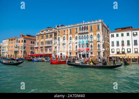 Venedig, Italien - 3. August 2019: Gandoliers fahren Touristen auf Gondeln am Canale Grande Stockfoto