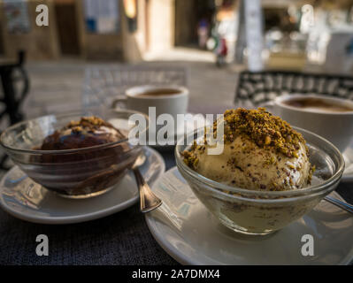 Traditionelle kalabrische Tartufo Eis chcocolate creamin Tropea, Nougat und Pistazien Eis Kugeln und Kaffee auf einem Tisch vor einem Cafe Stockfoto