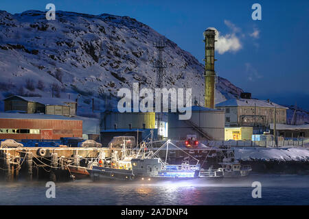 Die kleine Schiffe im Dock von Fisch verarbeitenden Betrieb bei Nacht. Teriberka, Region Murmansk, Kola Halbinsel. Russland Stockfoto