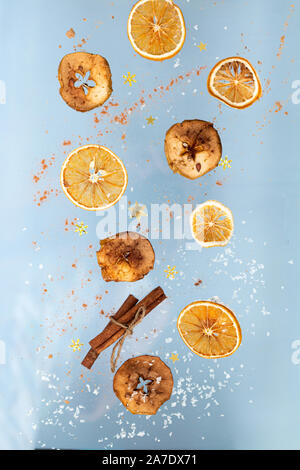 Ingwer cookies mit trockenen Apple und orangen Scheiben und Zimtstange Fliegen auf blauem Hintergrund. Essen Levitation. Weihnachten Konzept Stockfoto