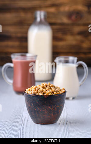 Schokolade, Milch und Soja Milch in Glas am weißen Tisch über dunklen Hintergrund Stockfoto