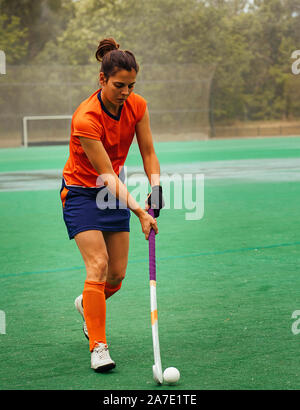 Weibliche Hockeyspieler Ausübung auf eine Rasenfläche. Stockfoto