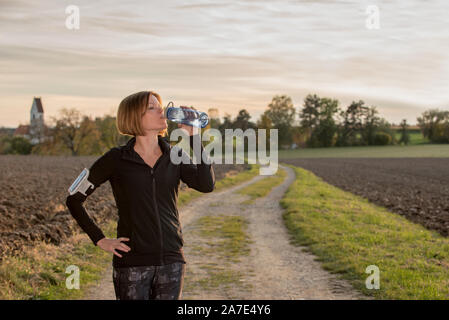 Nahaufnahme von junge Frau trinkt Wasser beim Sport Stockfoto