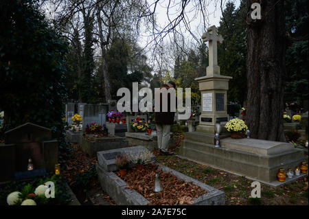 Ein Mann zahlt seinen Respekt, als Er besucht das Grab der verstorbenen Verwandten während der Feiern in der Allerheiligen am Friedhof Rakowicki. Der 1. November ist ein Tag weg von der Arbeit und Menschen besuchen die Gräber ihrer Lieben. Stockfoto