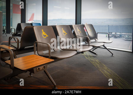 Leer deaktiviert Sitze an einem Flughafen im Wartebereich vor dem Einsteigen. Stockfoto