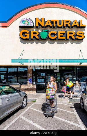 Durango, USA - 22. August 2019: Frau beenden Einkaufen mit Warenkorb und Taschen mit Vorzeichen vor dem Eingang zu den natürlichen Lebensmittelgeschäft Grocery Store durch Parken l Stockfoto