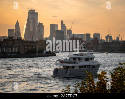 London/Großbritannien - 21. September 2019: Skyline von London bei Sonnenuntergang einschließlich einer Yacht im Vordergrund und der Londoner City im Hintergrund Stockfoto