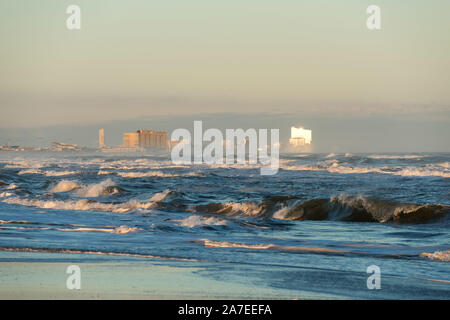 Die Atlantic City Skyline von Ocean Beach, New Jersey gesehen, mit der untergehenden Sonne reflektiert das Ocean Resort Casino in der Ferne. Stockfoto