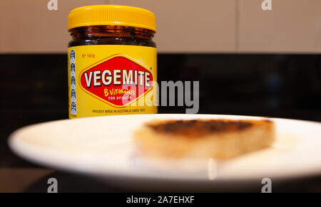 Sydney, Australien - 2 November, 2019 - Vegemite und Butter auf sauerteig Toast mit Vegemite jar im Hintergrund. Ein klassisches Symbol der Australischen ausbreiten. Stockfoto