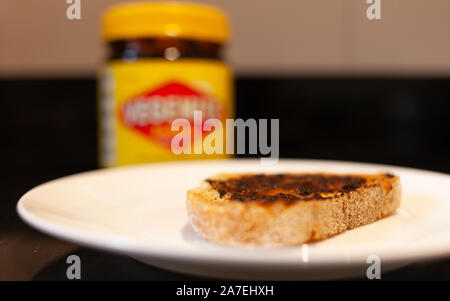 Sydney, Australien - 2 November, 2019 - Vegemite und Butter auf sauerteig Toast und Vegemite jar. Ein klassisches Symbol der Australischen ausbreiten. Stockfoto