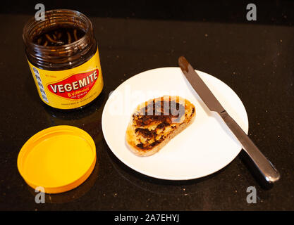 Sydney, Australien - 2 November, 2019 - Vegemite Toast und Butter auf Sauerteig, Messer und Vegemite jar. Ein klassisches Symbol der Australischen ausbreiten. Stockfoto